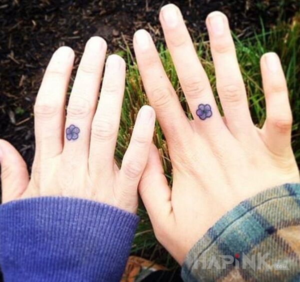 Tattoo Dwa kwiatki in colorful motif and minimalistic style on the fingers