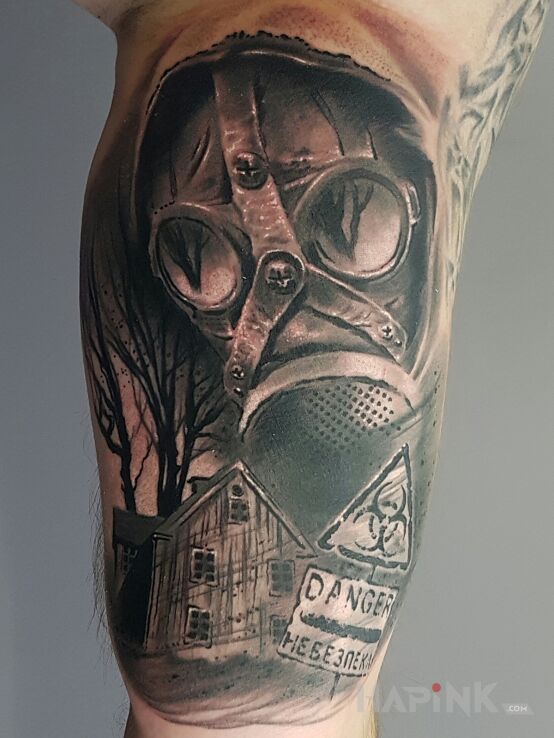 Tattoo Gas mask in war motif and realistic style on the upper arm
