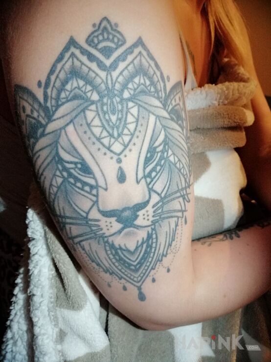 Tattoo Lion in ornaments motif and graphic / illustrative style on the upper arm