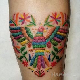 Tattoo Embroidered bird on the forearm motif: colorful style: embroidered