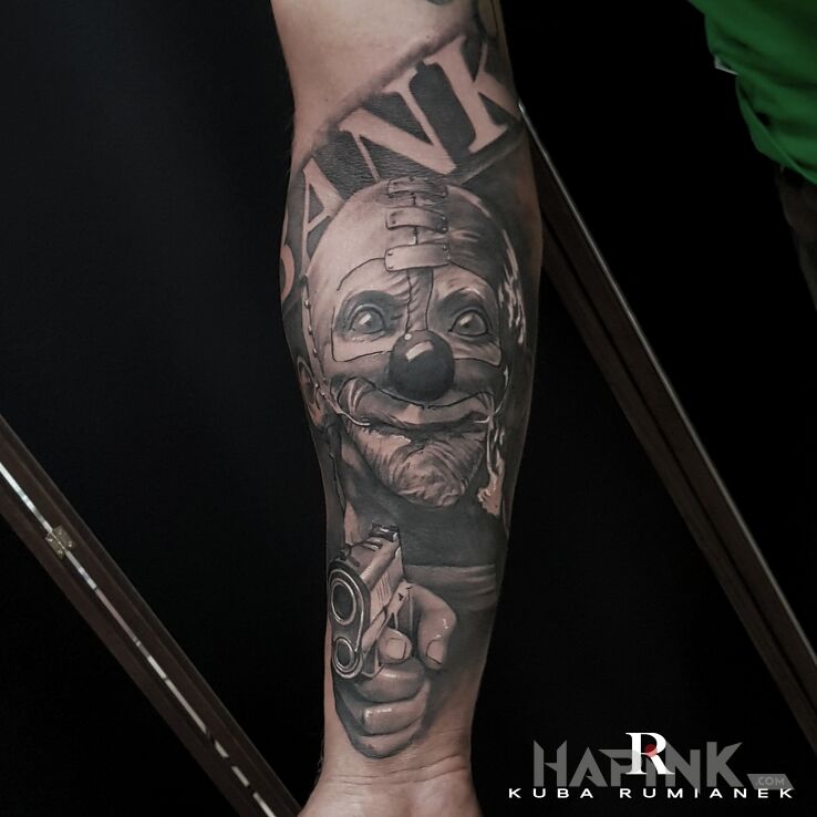 Tattoo Clown in faces motif and realistic style on the forearm