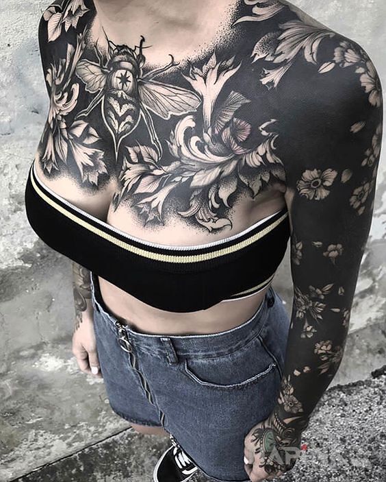 Tattoo Czaaaarno in flowers motif and blackwork / blackout style on the forearm