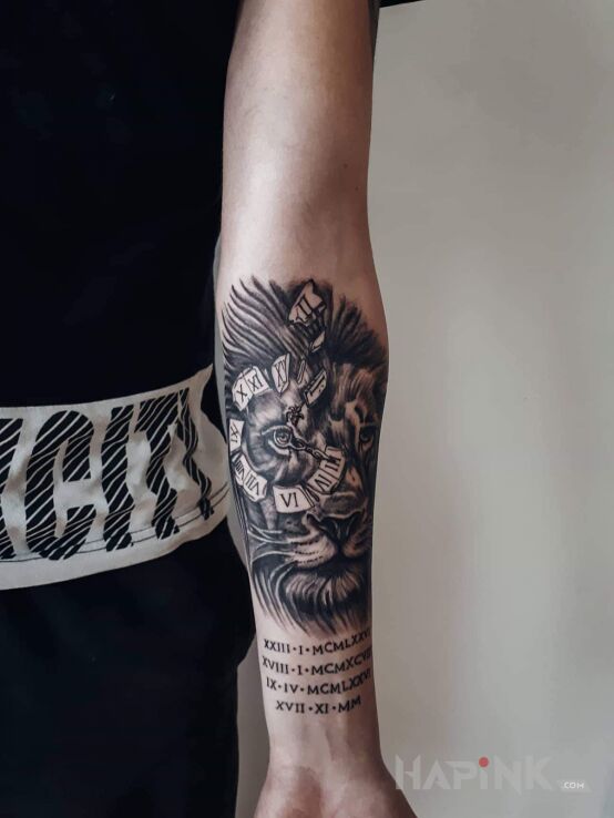 Tattoo Lew z zegarem in zodiac signs motif and realistic style on the forearm