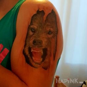 Tattoo The wolf under the skin on the upper arm motif: animals style: realistic