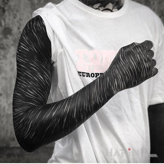 Tattoo Ciekawy rękaw in sleeves motif and blackwork / blackout style on the forearm