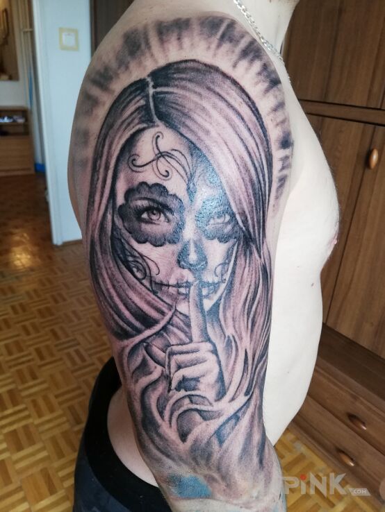 Tattoo Nie mów nic nikomu! in black and gray motif and realistic style on the upper arm