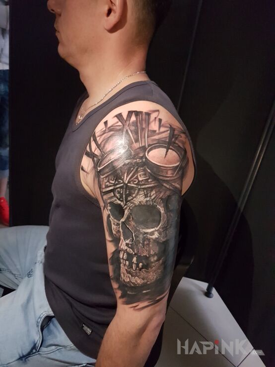 Tattoo SKULL in black and gray motif and realistic style on the upper arm