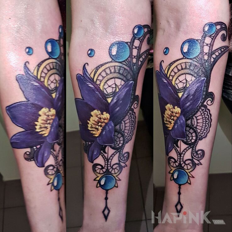 Tattoo Mandalo kwiaty in ornaments motif and realistic style on the forearm