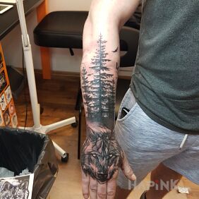 Tattoo Wolf forest on the forearm motif: black and gray style: graphic / illustrative
