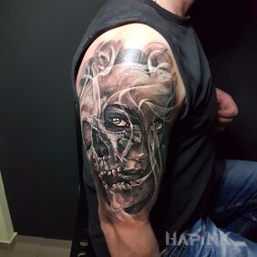 Tattoo 2Face on the upper arm motif: faces style: realistic