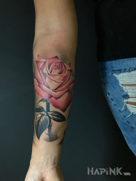 Tattoo Róża in colorful motif and realistic style on the forearm