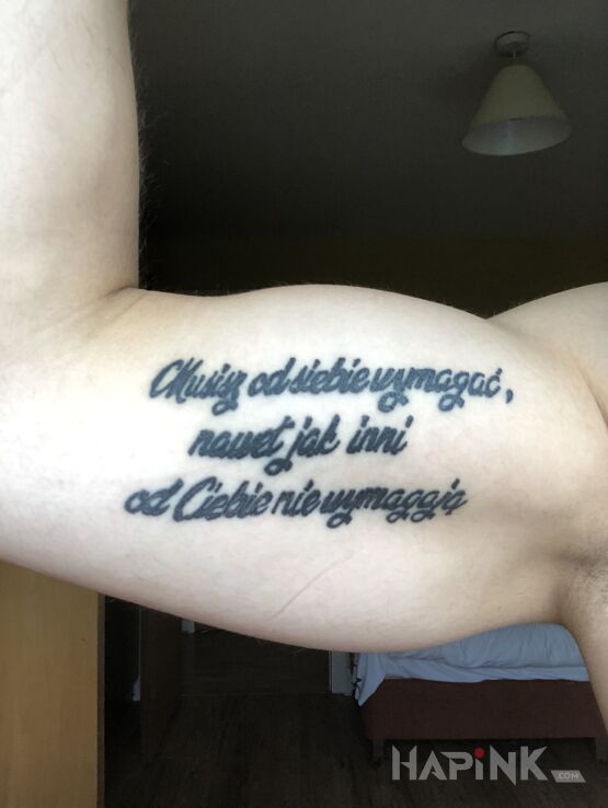 Tattoo Sentencja in lettering motif and calligraphy style on the upper arm
