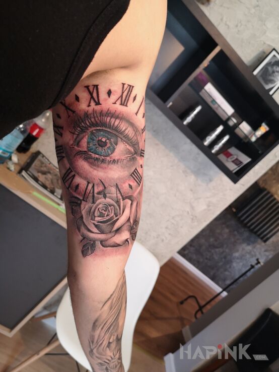 Tattoo Oko czas zegar roza in black and gray motif and realistic style on the upper arm